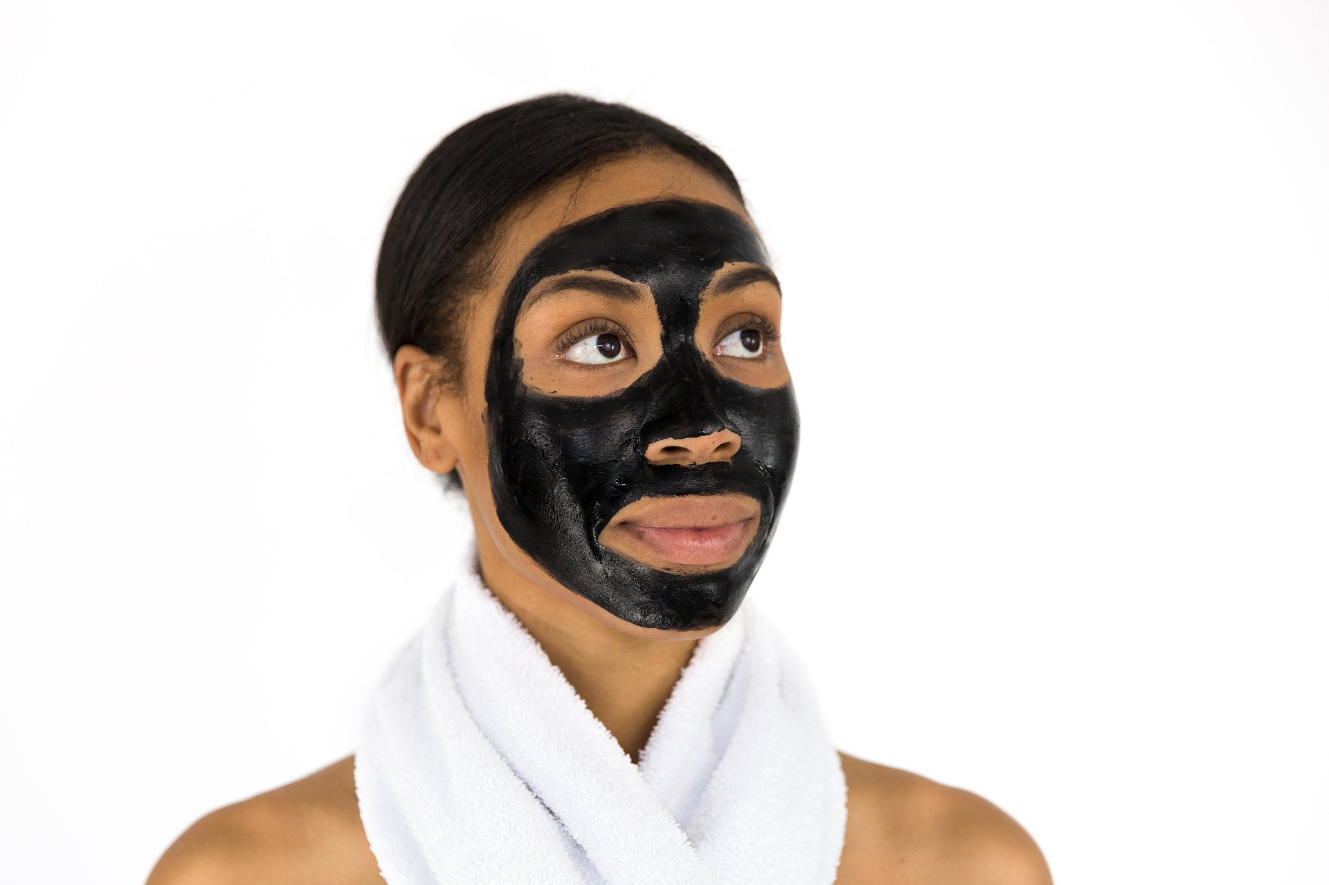 Hautprobleme behandeln Frau trägt eine schwarze Gesichtsmaske aus Creme.